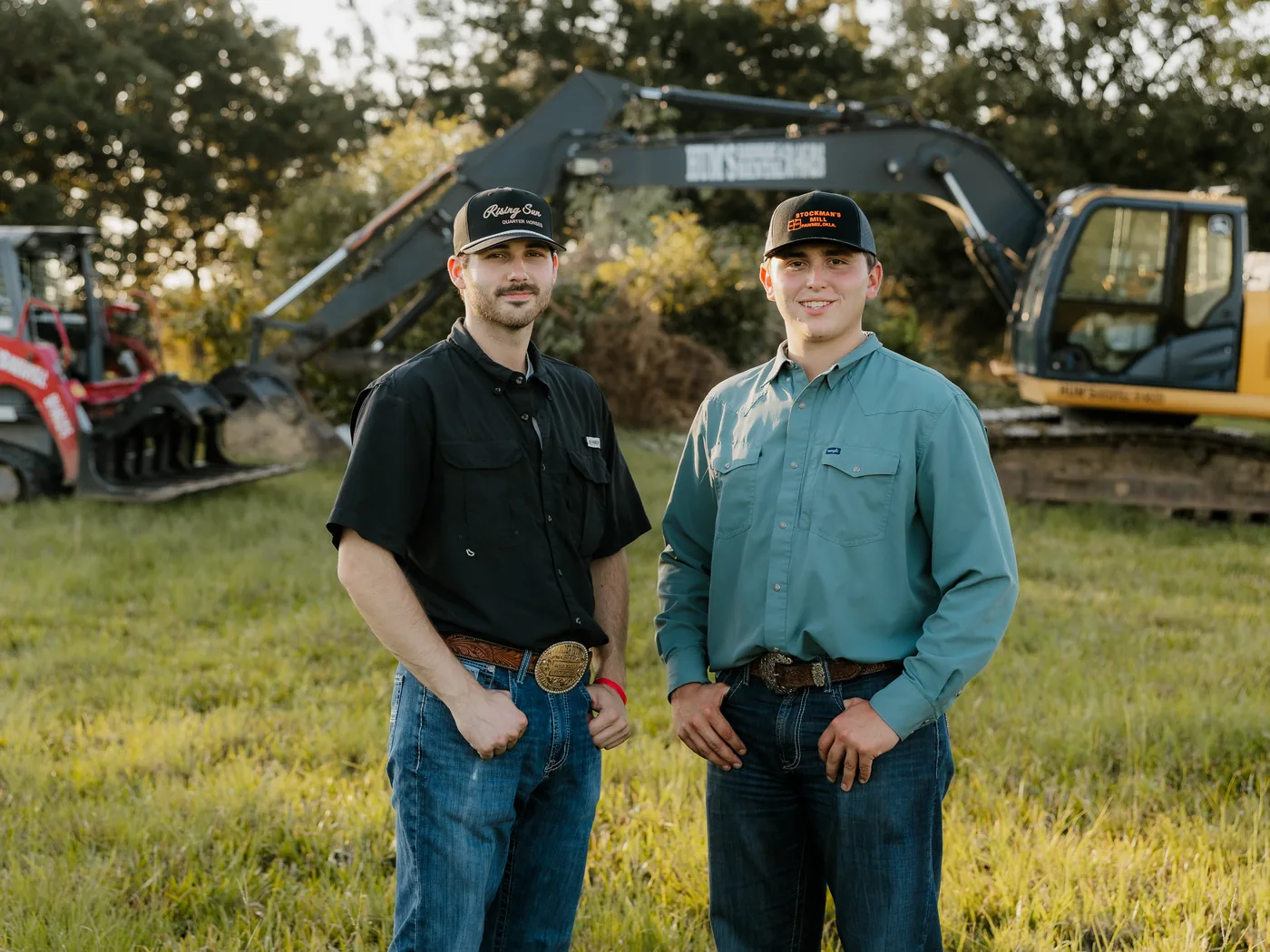 Luke Atchison and Grady Harris standing in front of their equipment on a job site